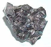 Un bulto negro brillante de sólido con superficie irregular.