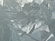 Cristales alargados fusionadas de varios tonos de gris.