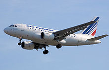 Aviones jet blanco entra en la pista, tren de aterrizaje completamente extendido. Bajo cada ala es un motor turbofan
