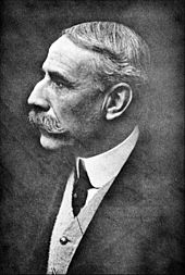 fotografía de un hombre a finales de la edad media, con una gran nariz romana, un retroceso de cabello, y un gran bigote. Él se muestra en el perfil izquierdo