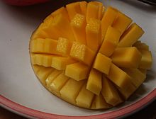 Un reducido a la mitad, de dentro a fuera de mango se corta en un patrón de rejilla, todavía unido a la cáscara. El mango es de adentro hacia afuera, haciendo que los rectángulos resultantes de fruta para splay en un patrón similar a los tentáculos de un erizo de mar.
