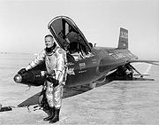 Una foto en blanco y negro de Armstrong sonríe afuera de un X-15