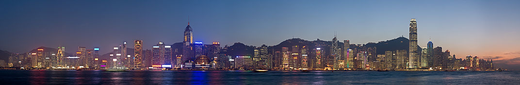 Horizonte de la ciudad la noche con el puerto de Victoria en frente y detrás de las colinas bajas