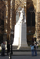 Pierre blanche statue de George V de robes rayées sur un socle de la même pierre debout dans une rue