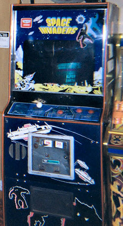 Une borne d'arcade bleu avec un écran entouré de décalcomanies. Les contrôles de jeu sont assis en dessous de l'écran, tandis que la phrase