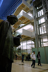 Patrons marchant vers la porte dans le hall avec la sculpture de Athena éventuellement sur la gauche