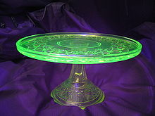 Un lieu de verre sur un support de verre. La plaque est allumé vert tandis que le stand est incolore.