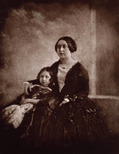Victoria câlins un enfant à côté d'elle