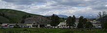 Un groupe de bâtiments avec des arbres et des collines en arrière-plan