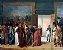 Un groupe d'hommes, certains portant des barbes et des turbans, sont dans une chambre avec un grand tableau sur le mur, ils regardent vers une porte porter un homme en uniforme militaire, y compris johphurs blancs (Napoléon) revient sur eux et a sa main droite son gilet.