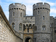 Une photographie d'une guérite en pierre, avec deux grandes tours circulaires de chaque côté de la passerelle dominant l'image. Un mur de pierre se étend le long du côté gauche de l'image.