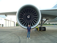 de moteurs d'avions, vue vers l'avant avec un ingénieur de Boeing en face de démontrer la taille du moteur. Grande prise circulaire du moteur contient un moyeu central avec une marque de tourbillon, entouré de plusieurs pales de ventilateur courbes.