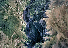 Jagged zone bleu foncé de la gorge fonctionnement former en bas à gauche en haut à droite, entouré de brun et vert des zones plus élevées de terres