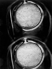 Deux cercles lumineux sur fond sombre, deux contiennent de nombreuses fines lignes noires à l'intérieur.