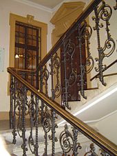 Escalier ornementé, un palier avec une porte intérieure et la fenêtre, escalier continue jusqu'à