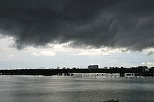 Les nuages d'orage sombre sur un plan d'eau avec des bâtiments en arrière-plan bien