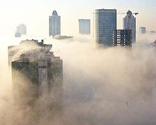 Gratte-ciel, à la fois proche et lointain, planent au-dessus d'une couche dense de brouillard qui maintient le sol caché de la vue.