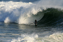 Photo de surfeur au bas de la vague, en essayant de laisser le tube lui envelopper