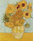 Un vase sur une table avec une douzaine de fleurs de différentes nuances de jaune, beige et beige; quelques-uns au sommet ont des centres plus sombres et une sur la gauche est vert