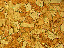 Um padrão Mosaica composto por componentes que têm várias formas e tons de marrom.