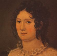 Retrato de uma mulher que mostra seu pescoço e cabeça. Ela tem cabelos castanhos em cachos ringlet e podemos ver o plissado a partir do topo de seu vestido. A pintura é feita em uma paleta de laranjas e marrons.