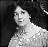 Cabeça e ombros tiro de uma mulher Edwardian com cabelo escuro, olhando para a câmera