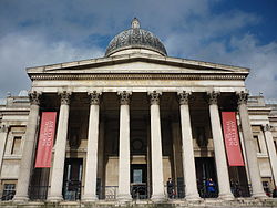 O pórtico de entrada virada para Trafalgar Square. A inscrição foi adicionada durante o trabalho de remodelação do edifício em 2004-5. [41]