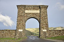 Um grande arco de pedra natural forma irregular ao longo de uma estrada