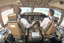A cabine de pilotagem, assentos de trás os dois pilotos '. A consola central encontra-se entre os assentos, na frente de um painel de instrumentos com vários monitores, e de luz que entra através das janelas para a frente.