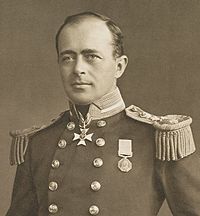 Homem com calvície, olhando para a esquerda, vestindo uniforme naval com as medalhas, botões polida e grandes dragonas