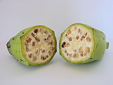 Foto de duas metades em corte transversal de fruta cheio de sementes.