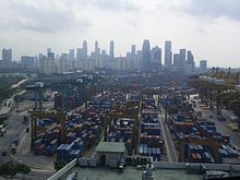 O porto de Cingapura, com um grande número de contentores marítimos com o skyline da cidade visível no fundo